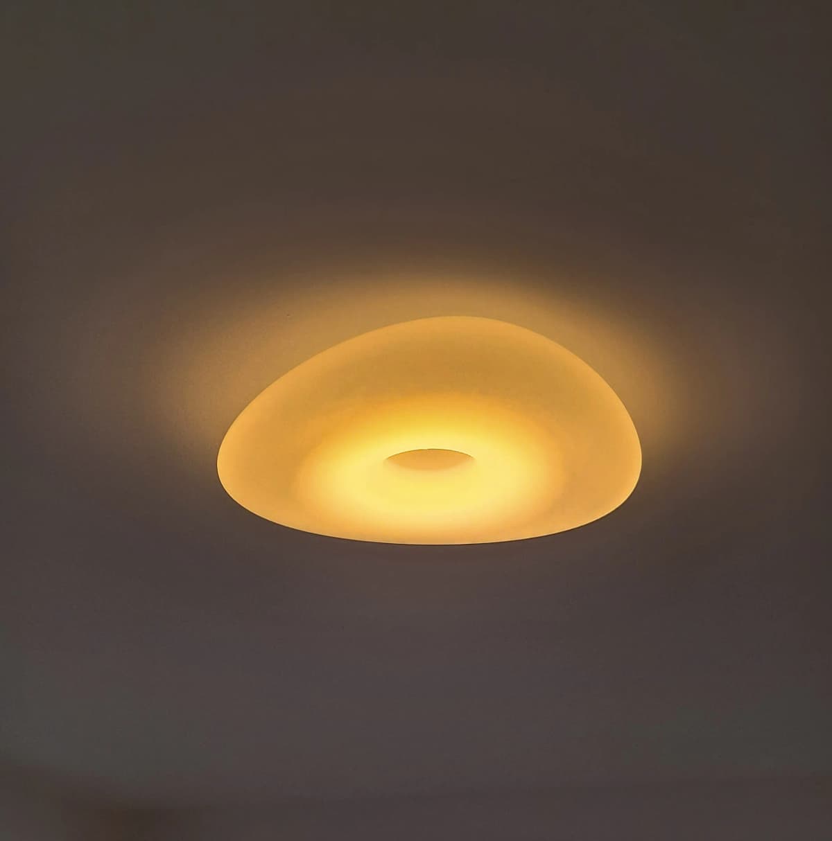 Moderné stropné LED svietidlo vyžarujúce teplé žlté svetlo